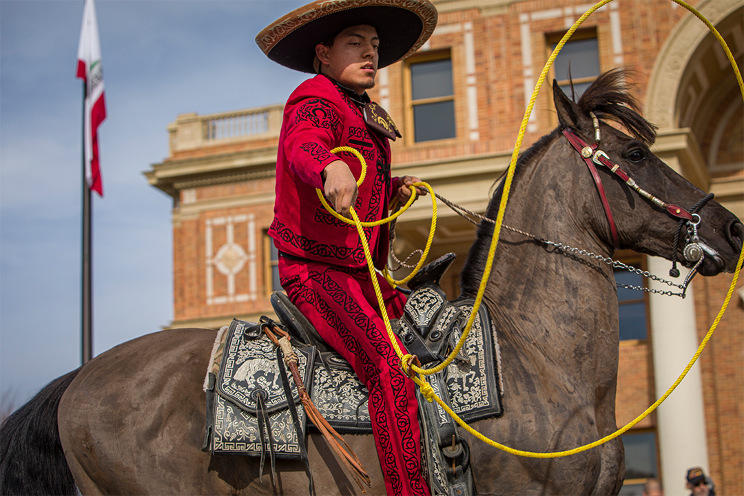 Image of man riding a dancing horse and swinging a lasso in front of Atascadero City Hall - Photo by Keith Bergher